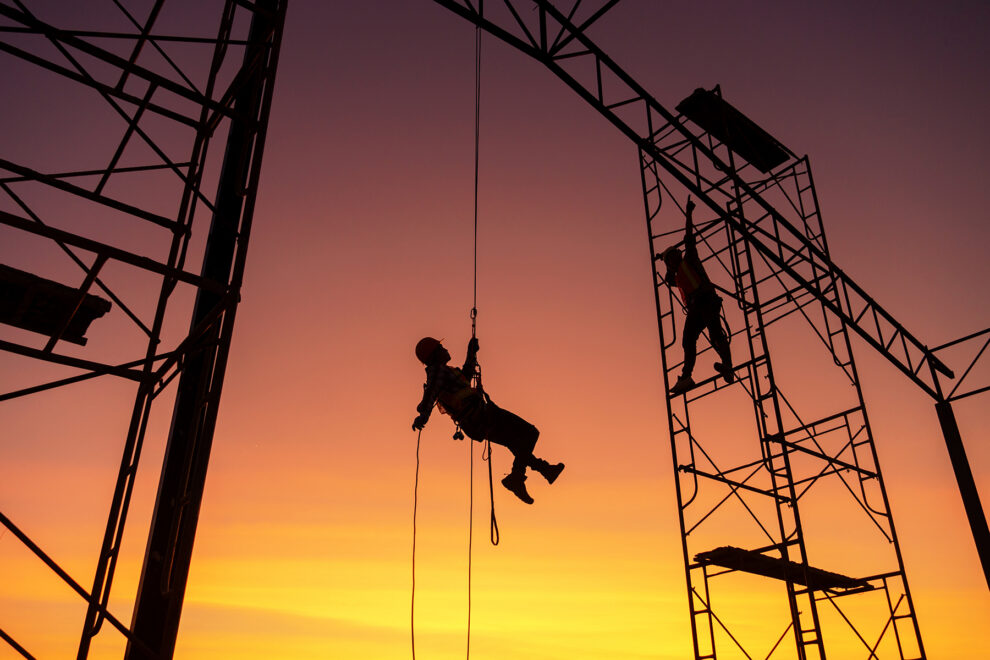 Male working abseiling on a construction site silhouette worker